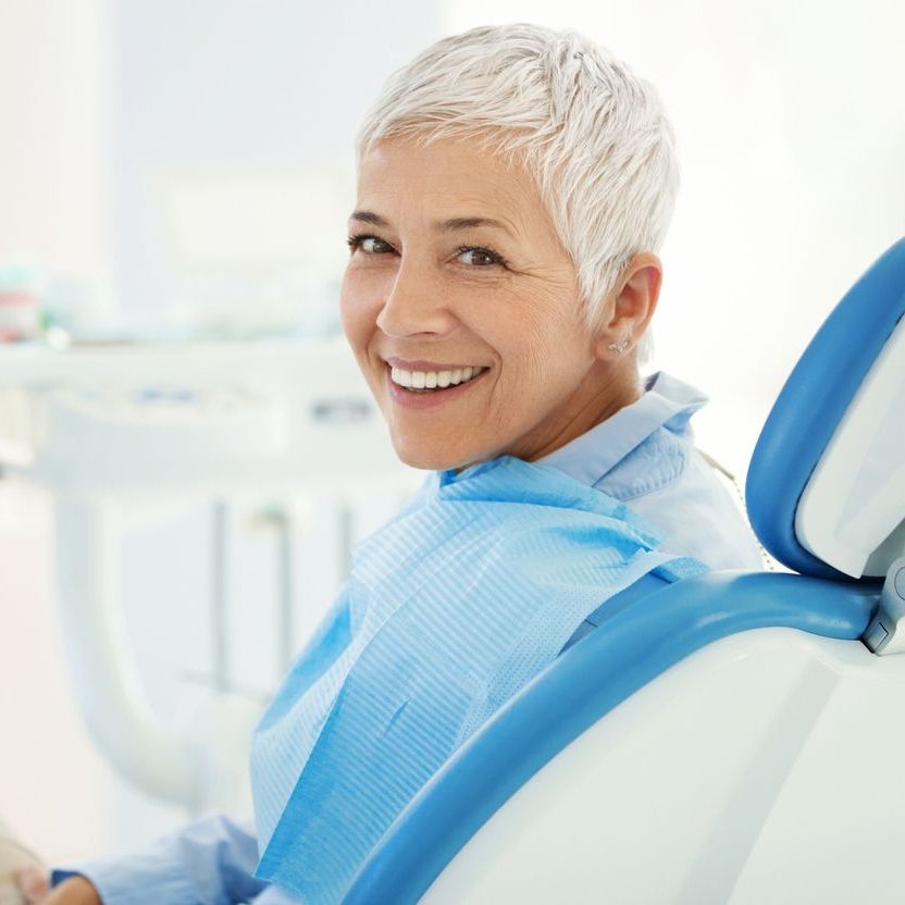 Woman smiling sitting in a dentist chair