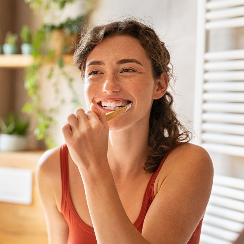 Woman brushing teeth at mirror